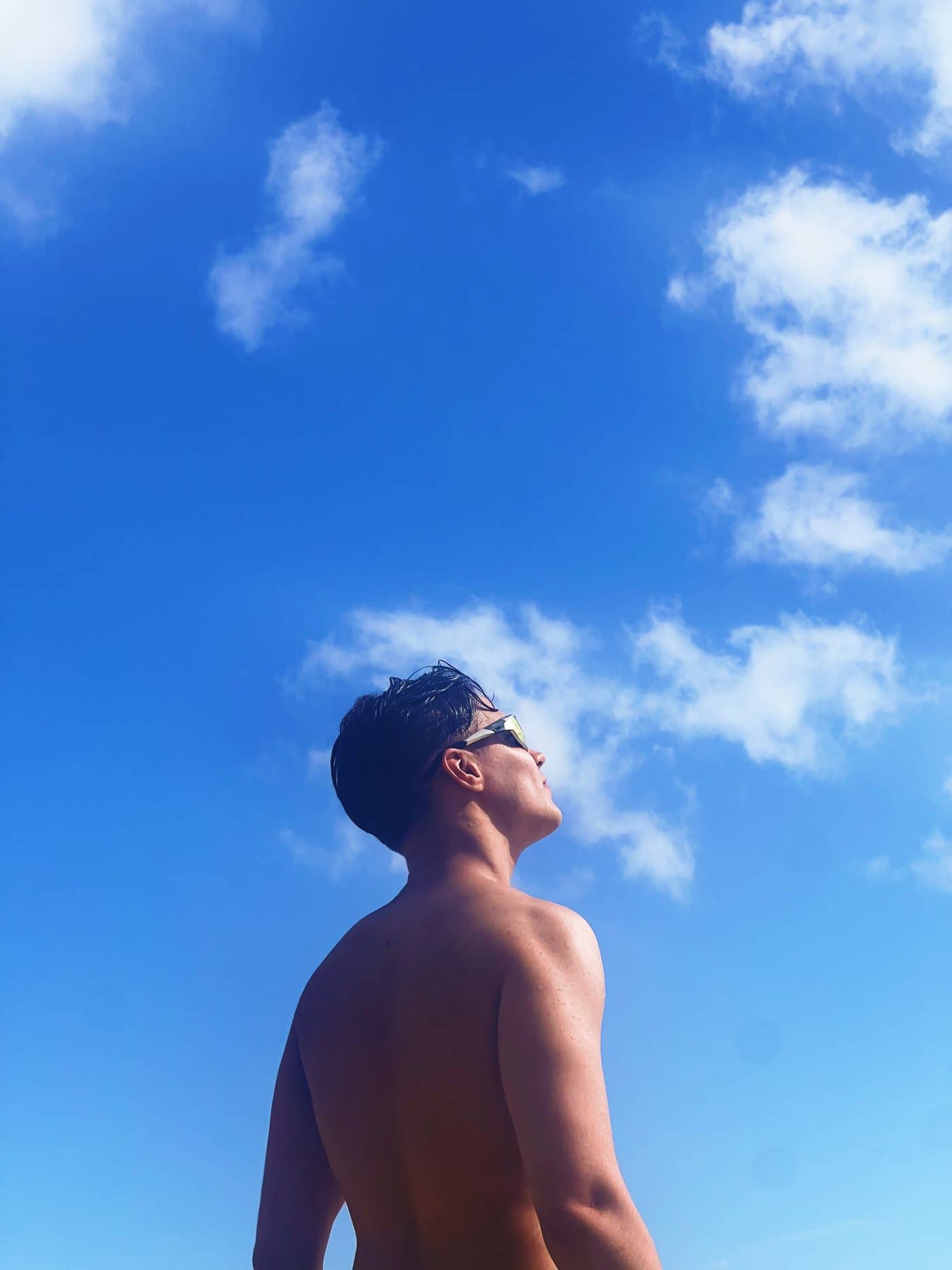 Lucas looking up into a bright sky at Les Salines in Martinique