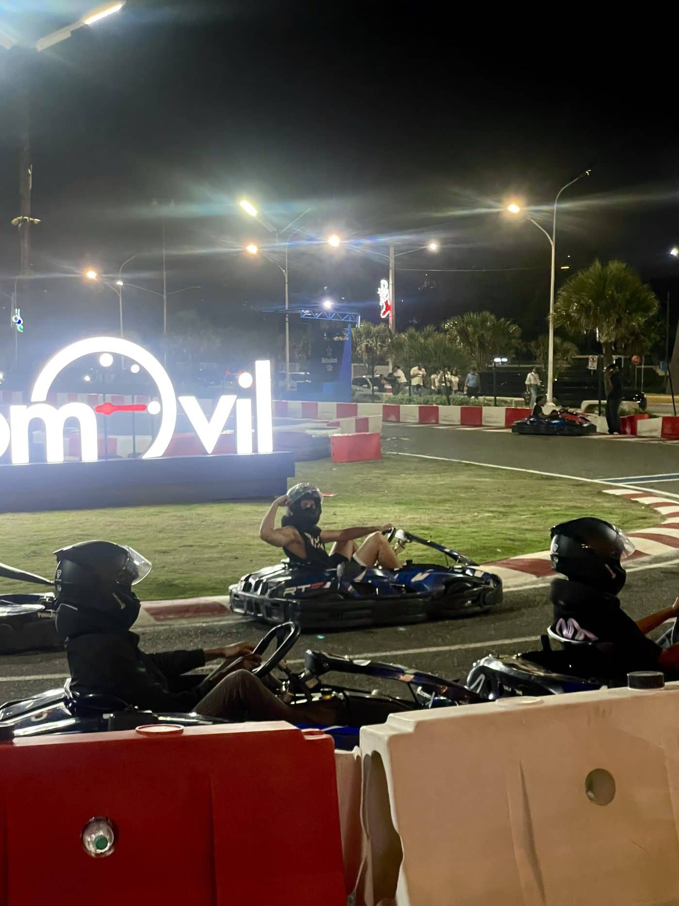 Lucas in a go-kart at night, adjusting his helmet
