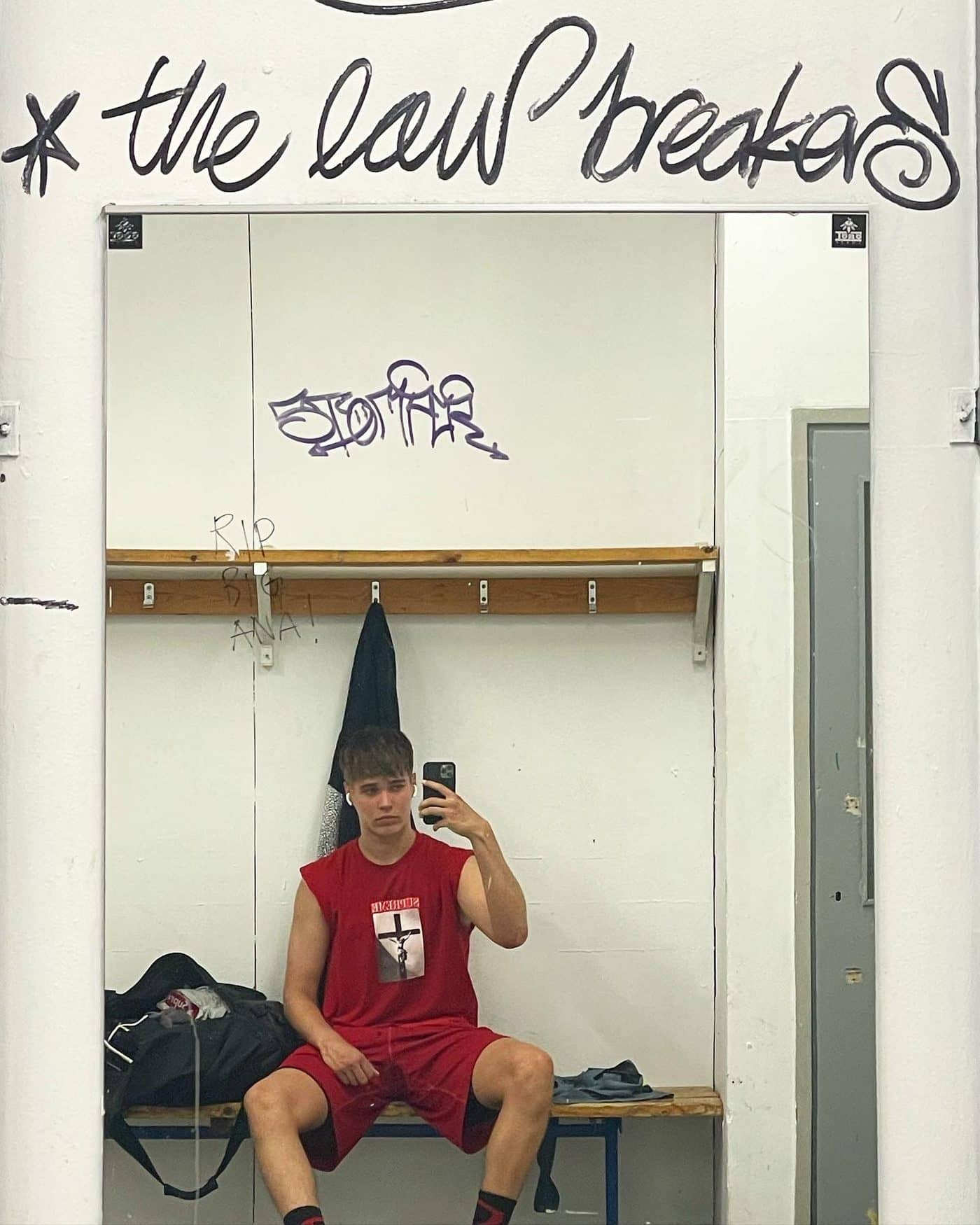 Lucas sitting in a locker room in a red jersey
