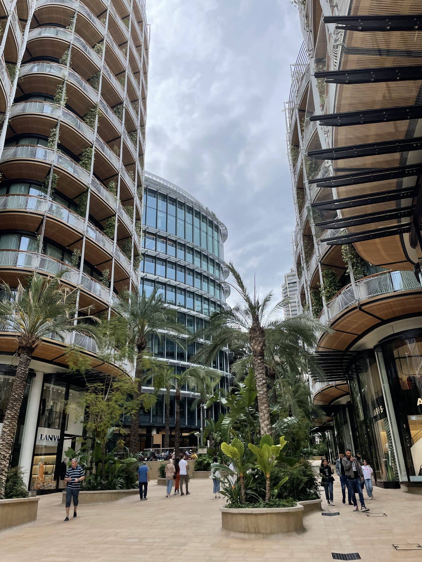 A palm-lined plaza between curved towers in Monte Carlo