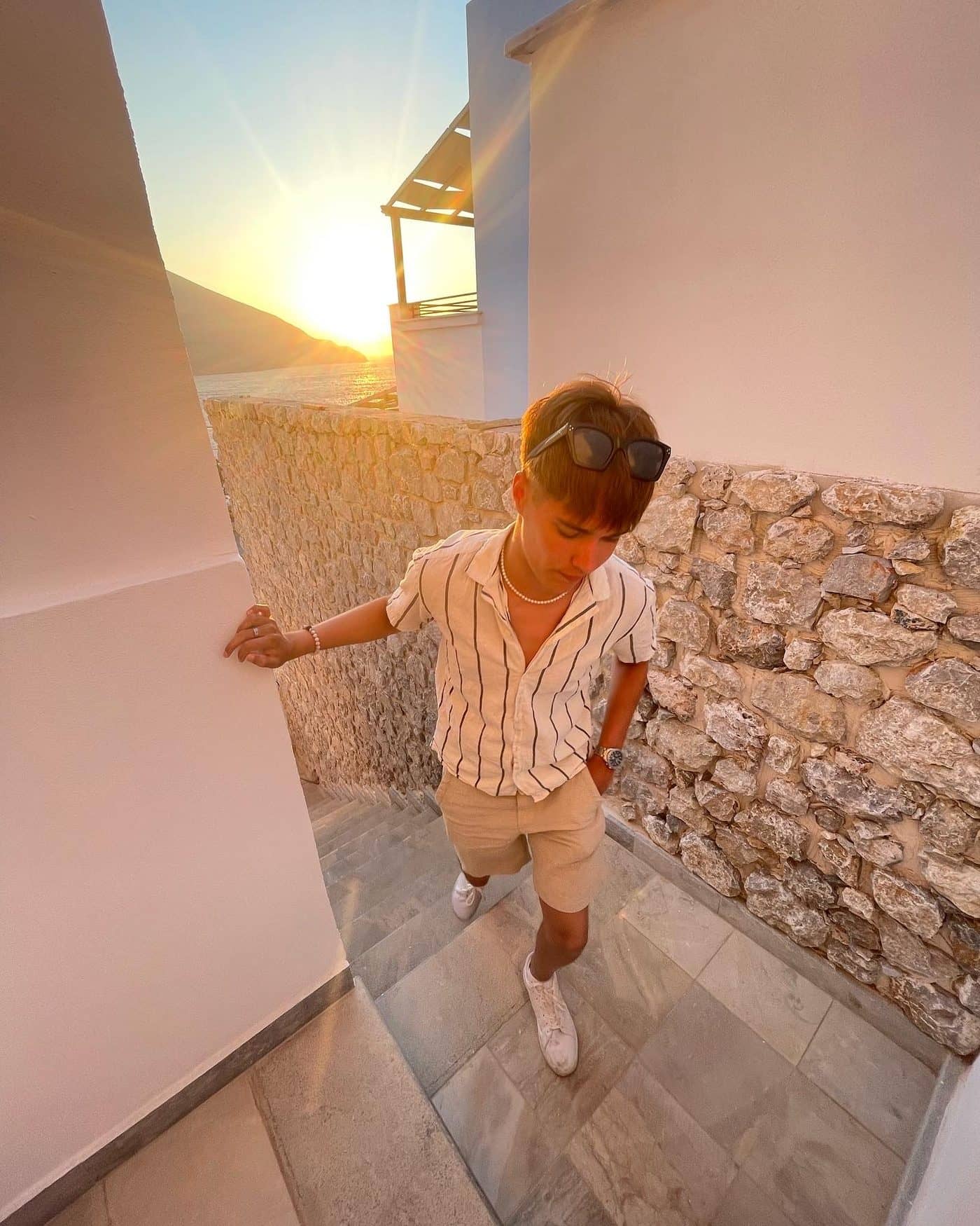 Lucas in a whitewashed alley in Greece at sunset
